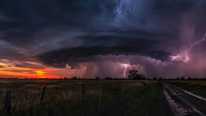 tormenta-severa-campo-anochecer Tormenta severa con fuertes relámpagos y cortina de lluvia sobre un campo al anochecer.