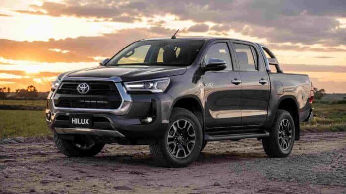 toyota-hilux-campo-argentino Pick up Toyota Hilux estacionada en un entorno rural al atardecer, con campos y cielo parcialmente nublado de fondo.