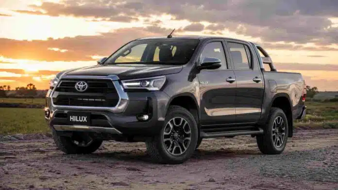 toyota-hilux-campo-argentino Pick up Toyota Hilux estacionada en un entorno rural al atardecer, con campos y cielo parcialmente nublado de fondo.