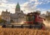 El agro busca instalar en el Presupuesto 2027 el debate por los “impuestos ocultos” que van más allá de las retenciones Cosechadora roja trabajando sobre un lote de soja con el Congreso de la Nación Argentina de fondo.