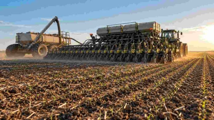 Sembradora de gran porte y carro de insumos trabajando en la implantación de un cultivo, en una escena que representa la inversión agrícola de la campaña 2025/26.
