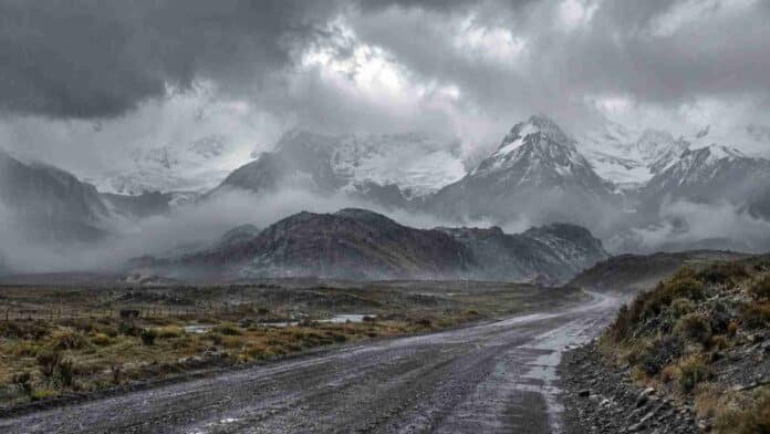 lluvias-nevadas-patagonia-alerta-ruralnet Camino cordillerano de la Patagonia bajo lluvias y nevadas, con montañas cubiertas de nieve y baja visibilidad por el temporal.
