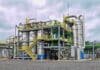 Argentina autorizó una nueva levadura transgénica para producir bioetanol Planta industrial de procesamiento con tuberías, torres y tanques de acero, utilizada en la producción de insumos y derivados químicos.