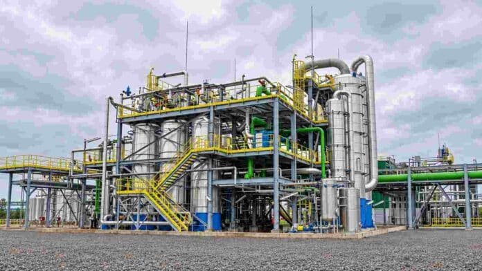 Planta industrial de procesamiento con tuberías, torres y tanques de acero, utilizada en la producción de insumos y derivados químicos.