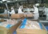 Argentina reabre el mercado de Japón para la carne aviar Operarios en una planta de procesamiento avícola envasando productos de pollo en cajas sobre una línea industrial.