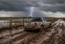 Pronóstico septiembre-octubre-noviembre: aumentan las chances de lluvia en zonas agrícolas clave Campo anegado y camino rural con barro y una camioneta encajada bajo una tormenta, en el marco del pronóstico de lluvias para septiembre, octubre y noviembre de 2026.