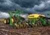 Girasol 2026/27: la siembra ya cubre el 26,6% del área prevista Tractor y sembradora John Deere trabajan sobre un lote con suelo húmedo bajo un cielo de tormenta con nubes oscuras.