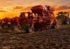 La estabilidad climática aceleró la cosecha y las siembras en Santa Fe Sembradora trabajando sobre suelo húmedo en un campo de la Pampa Húmeda durante un atardecer de cielo naranja.