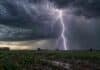 Pronóstico de heladas para el agro: así viene el clima de martes a jueves Fuerte tormenta eléctrica con un relámpago impactando sobre un campo rural cultivado bajo un cielo oscuro y cargado.