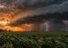 Alerta meteorológica en 17 provincias y CABA: tormentas severas y lluvias activan nivel naranja Tormenta severa sobre un campo agrícola al atardecer, con una gran nube de tormenta, lluvias intensas y fuertes descargas eléctricas en el horizonte.