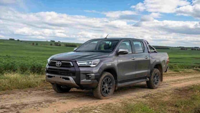 toyota-hilux-campo-argentina Toyota Hilux gris estacionada sobre un camino rural, rodeada de campos cultivados en una zona agrícola de Argentina.