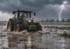 El Niño gana fuerza: hay 75% de chances de que alcance una intensidad histórica Tractor con conductor avanzando por un campo inundado bajo lluvia intensa y relámpagos, en una escena rural asociada al impacto de El Niño