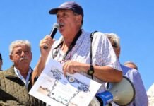 El campo despide a Armando Zavala, referente de los autoconvocados y fundador de Barbechando Armando Zabala habla con un micrófono durante un acto rural, acompañado por productores agropecuarios, mientras sostiene un reconocimiento.
