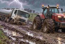 Pronóstico para miércoles, jueves y viernes: dónde persisten las lluvias y cuándo afloja la inestabilidad Camión cisterna lechero encajado en el barro mientras un tractor Massey Ferguson con duales lo remolca bajo la lluvia y un relámpago en un camino rural.
