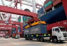 Argentina logró exportaciones récord y un superávit de US$ 2.976 millones Camiones transportan contenedores de carga en una terminal portuaria, mientras grúas de gran porte operan junto a un buque de carga en el marco del comercio internacional.
