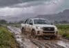 Prevén lluvias de hasta 40 mm en Córdoba este sábado 17 y tormentas en la Patagonia Camino rural embarrado bajo la lluvia con una camioneta Hilux blanca salpicada de barro avanzando entre charcos, en un paisaje agropecuario con tormenta.