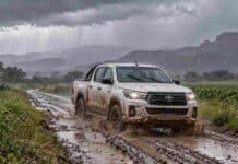 Prevén lluvias de hasta 40 mm en Córdoba este sábado 17 y tormentas en la Patagonia Camino rural embarrado bajo la lluvia con una camioneta Hilux blanca salpicada de barro avanzando entre charcos, en un paisaje agropecuario con tormenta.