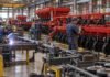 Maquinaria agrícola en alerta: 31% menos de producción y 5% menos de empleo formal Operarios trabajan en una planta industrial de maquinaria agrícola, con una línea de ensamblaje de sembradoras y estructuras metálicas en producción.