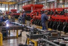 Maquinaria agrícola en alerta: 31% menos de producción y 5% menos de empleo formal Operarios trabajan en una planta industrial de maquinaria agrícola, con una línea de ensamblaje de sembradoras y estructuras metálicas en producción.