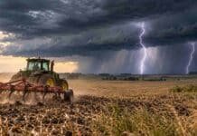 Pronóstico del 21 al 23 de octubre: tormentas en el NEA, San Luis y La Pampa Tractor agrícola trabajando el suelo con un cincel bajo un frente de tormenta, con dos relámpagos, nubosidad intensa y lluvias en el horizonte rural argentino.