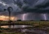 Pronóstico para martes, miércoles y jueves: tormentas fuertes en tres provincias y lluvias en la región Pampeana Molino rural junto a una aguada bajo un cielo de tormenta con dos relámpagos sobre un campo argentino.