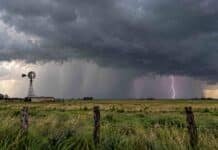Tormentas, lluvias intensas y ráfagas de más de 100 km/h: las zonas bajo alerta este martes 13 Tormenta fuerte sobre un campo rural con cortina de lluvia, relámpagos y cielo oscuro cargado.
