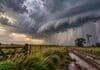 Pronóstico del 23 al 25 de octubre: tormentas fuertes en el NEA y descenso térmico Tormenta fuerte sobre un campo argentino, con nubes oscuras, un relámpago y lluvias intensas junto a un camino rural anegado.
