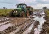 “Deterioro alarmante”: el reclamo del campo bonaerense por el uso de fondos viales en obras contra inundaciones Tractor avanzando con dificultad por un camino rural con barro y agua en la provincia de Buenos Aires.